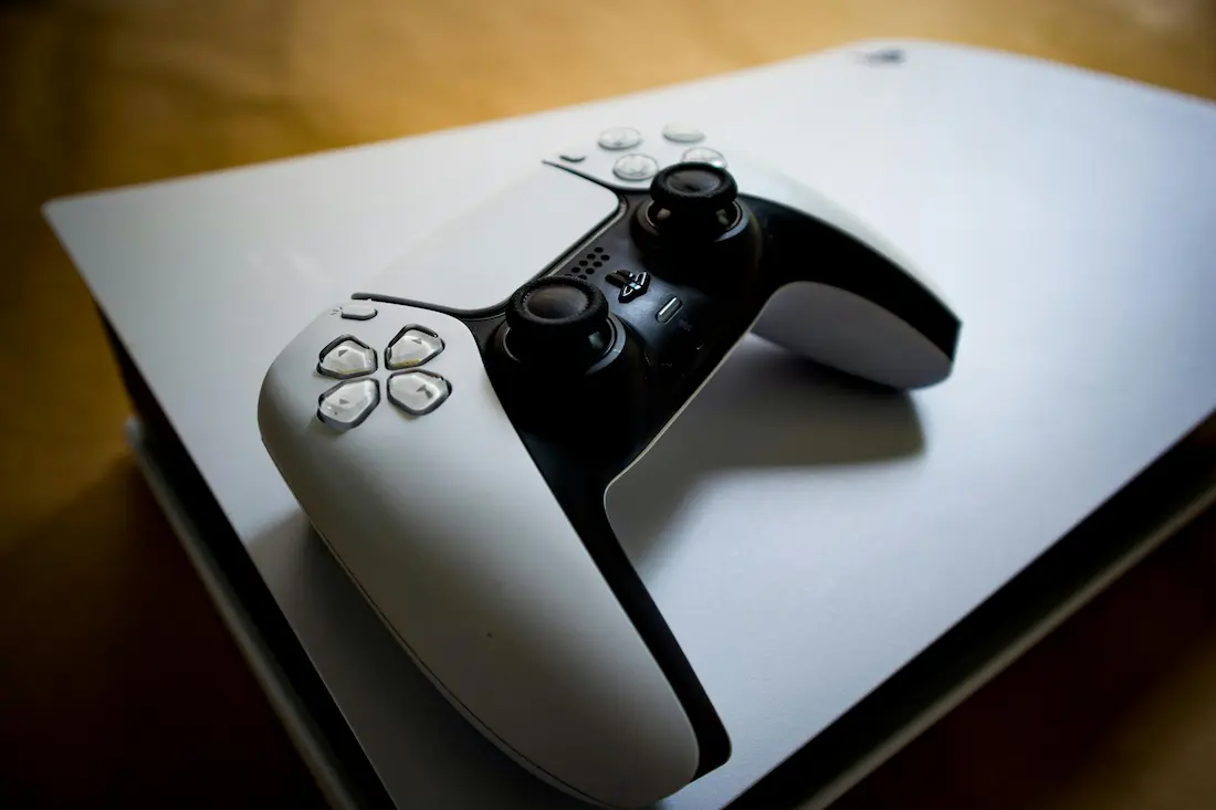 Mando DualSense sobre la consola PlayStation 5 blanca, representando la nueva era de seguridad digital y hardware cifrado.